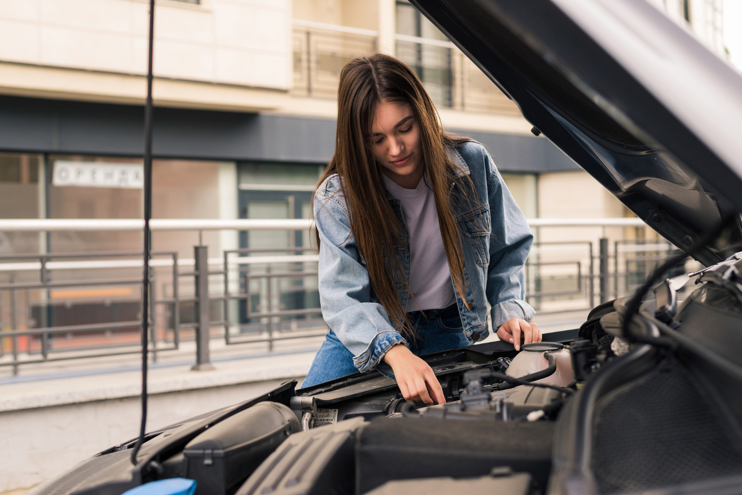 Mujer realizando comprobaciones para evitar problemas con las baterias del coche